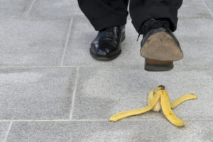 Businessman who may or may not need a slip and fall attorney after he trips on a banana peel