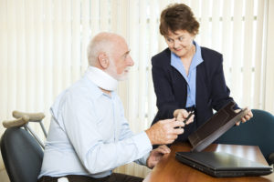 elderly man with neck brace signing a document his personal injury lawyer is giving him