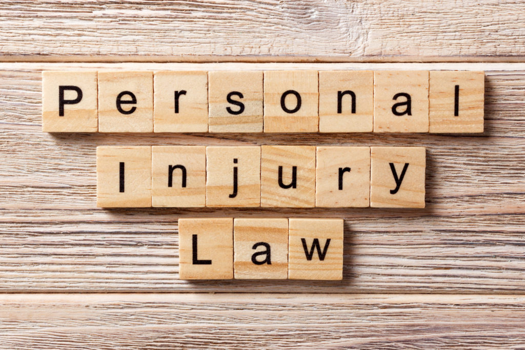 personal injury law word written on wood block. personal injury law text on table, concept