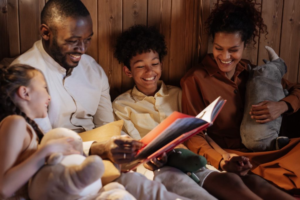 A young family of four reading stories before bedtime.